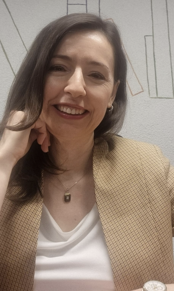 A smiling portrait of Serap Çelikli in natural light.